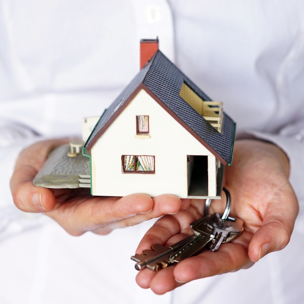 A vertical closeup shot of a person thinking of buying or selling a house